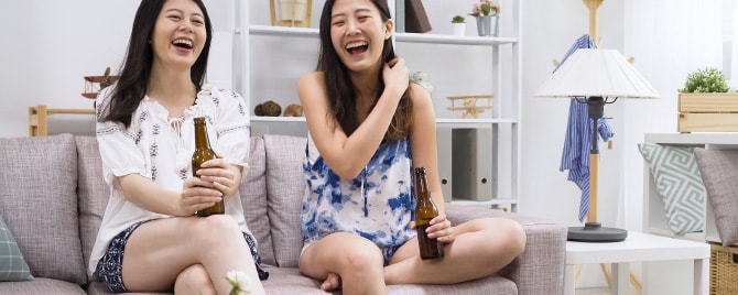 リビングで談笑しながらお酒を飲む二人の女性